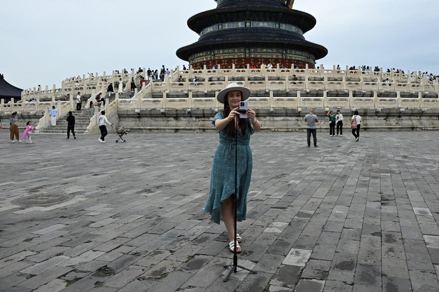 A representative of‍ an American travel agency⁣ takes a commemorative‍ photo at Beijing Tiantan on the 10th. (Photo/Xinhua News Agency)
